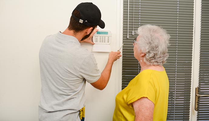 a man installing security lock in senior living housing.