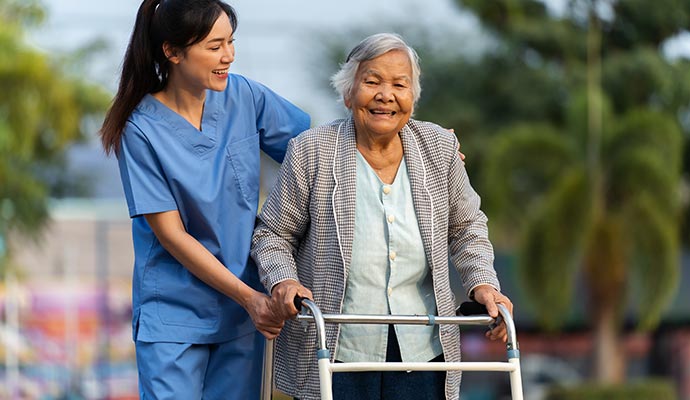 nurse helping elderly woman walk