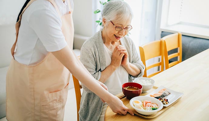 someone proving food to a old woman