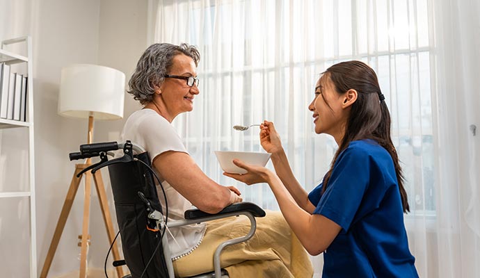 nurse feeding food to a senior resident