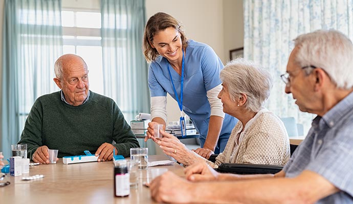 nurse giving medicine to a senior resident